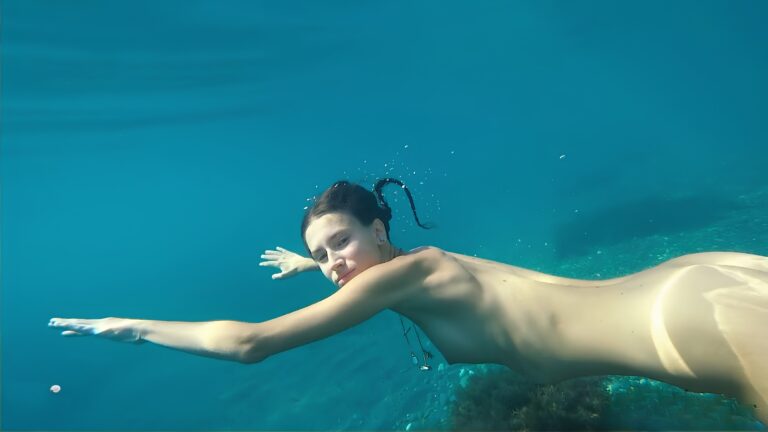 La encantadora Pela G nada desnuda en una playa pública