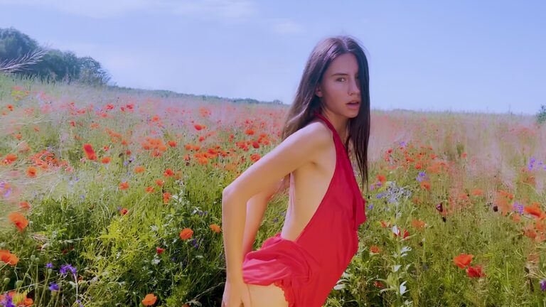 Una belleza esbelta se masturba en un campo de amapolas